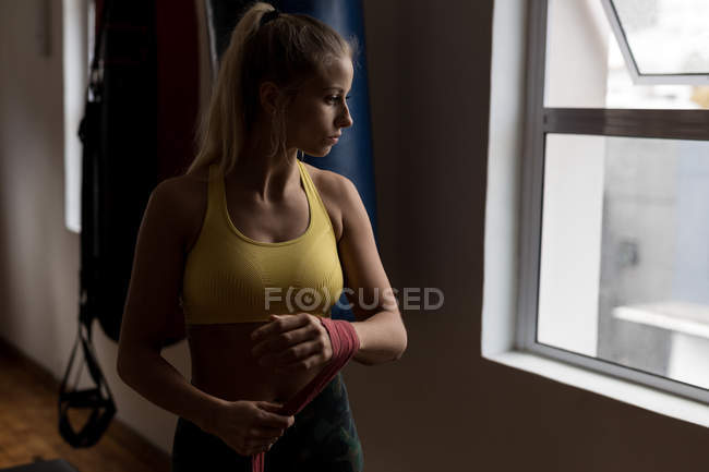 Jeune boxeuse enveloppée à la main dans un studio de fitness — Photo de stock