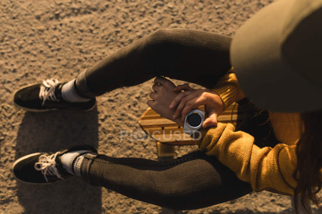 Visão de alto ângulo da mulher usando smartwatch na praia — Fotografia de Stock