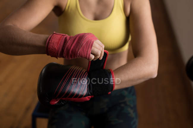 Close-up de boxeador feminino usando luvas de boxe no estúdio de fitness — Fotografia de Stock