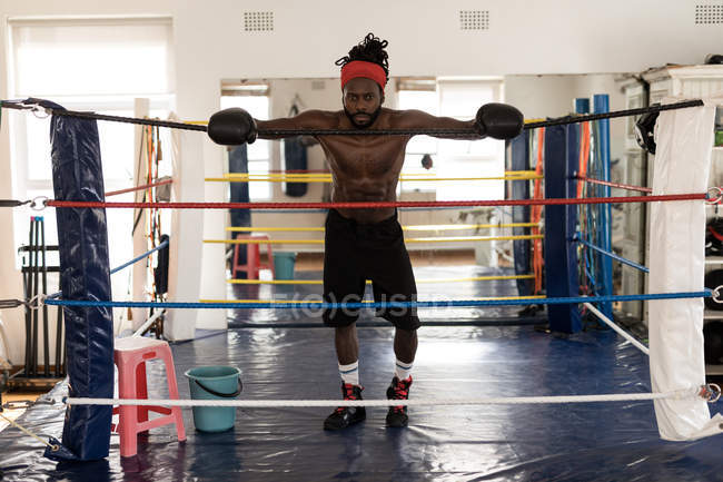 Sem camisa boxeador masculino em pé no ringue de boxe no estúdio de fitness — Fotografia de Stock