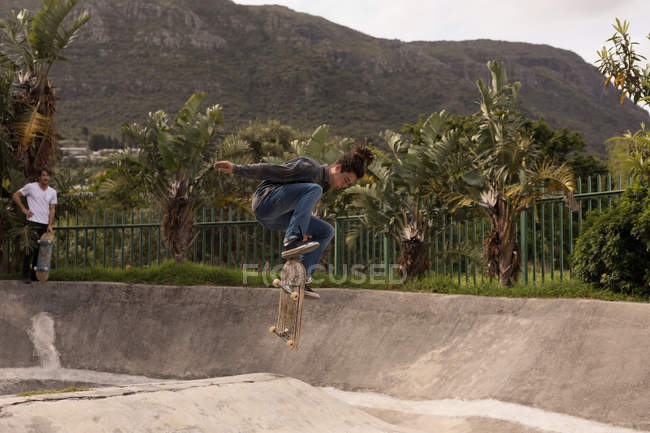 Joven skateboarding en skateboard park - foto de stock