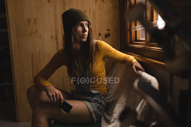 Nachdenkliche Frau blickt durch Fenster in Werkstatt — Stockfoto