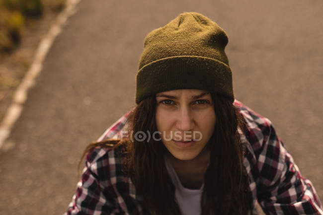 Портрет жінки скейтбордистки дивиться на камеру — стокове фото