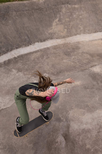 Высокоугольный вид женщины-скейтбордистки в скейт-парке — стоковое фото