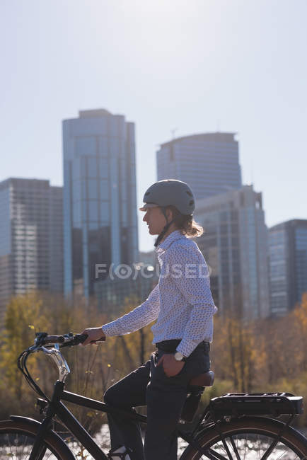 Young man relaxing on a bicycle in the city — Stock Photo