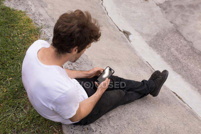Високий кут зору людини, що використовує мобільний телефон у парку скейтбордів — стокове фото