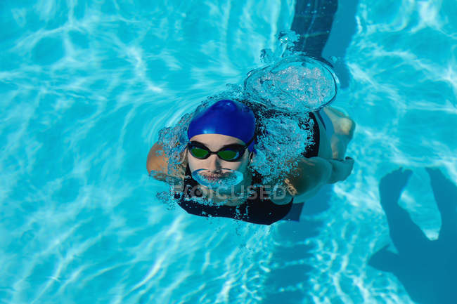 Высокий угол обзора молодой пловчихи плавающей фристайл в бассейне — стоковое фото