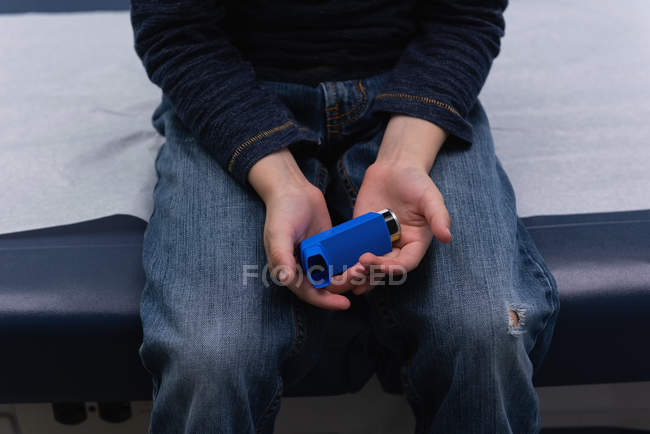 Partie médiane du garçon tenant l'inhalateur d'asthme à la main — Photo de stock