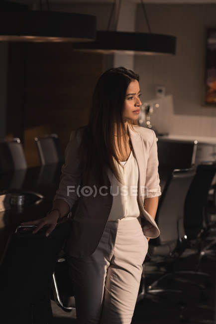 Вид спереду вдумлива бізнес-леді, що стоїть в конференц-залі в офісі — стокове фото