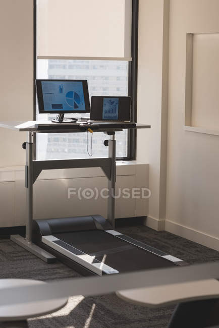 Personal computer, laptop and treadmill in the modern office — Stock Photo