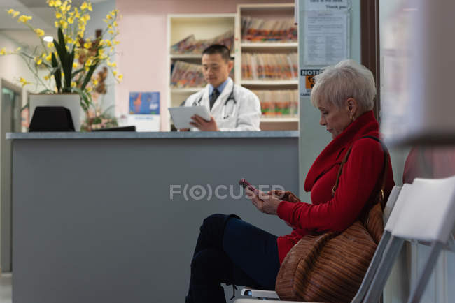 Seitenansicht einer kaukasischen Seniorin, die sich in der Klinik auf einem Stuhl entspannt — Stockfoto