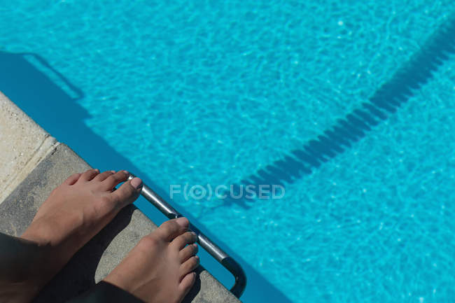 Vista de perto do pé descalço do nadador feminino em pé no bloco de partida na piscina ao sol — Fotografia de Stock
