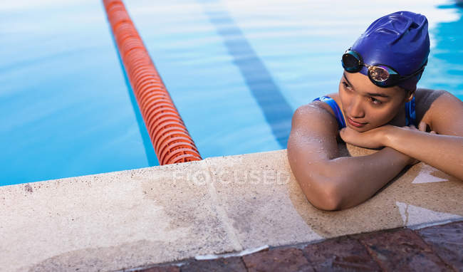Front view of female swimmer waiting on the edge of the swimming pool — Stock Photo
