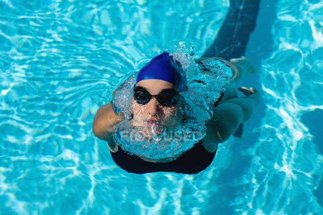 Blick aus der Vogelperspektive auf junge Schwimmerin beim Freistilschwimmen im Schwimmbad — Stockfoto
