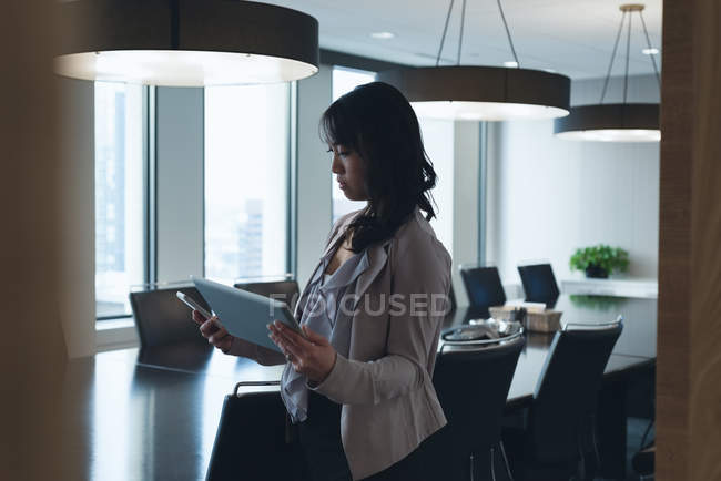 Вид збоку бізнес-леді, використовуючи цифровий стіл в конференц-залі в офісі — стокове фото