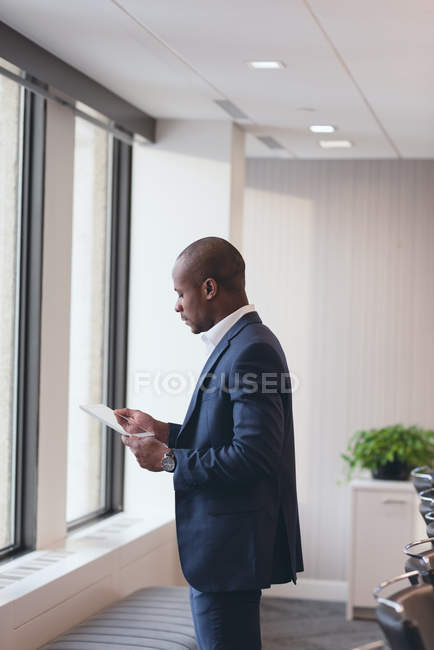 Vue latérale de l'homme d'affaires utilisant une tablette numérique dans la salle de conférence au bureau — Photo de stock