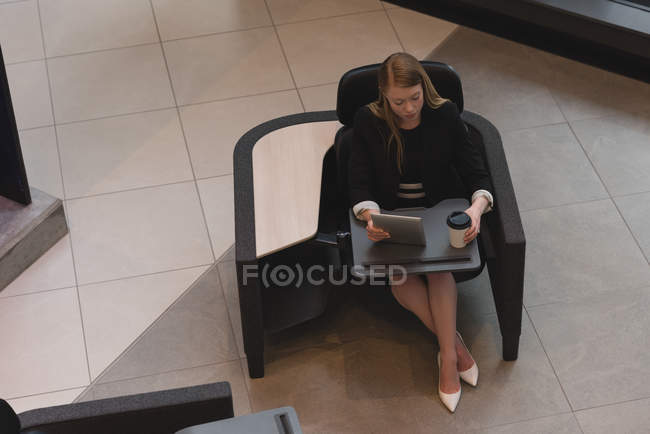 Ansicht von oben: Geschäftsfrau sitzt mit digitalem Tisch in der Lobby im Büro — Stockfoto