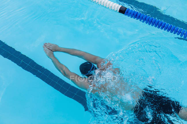 Vista de alto ângulo de um nadador masculino nadando peito debaixo d 'água na piscina — Fotografia de Stock