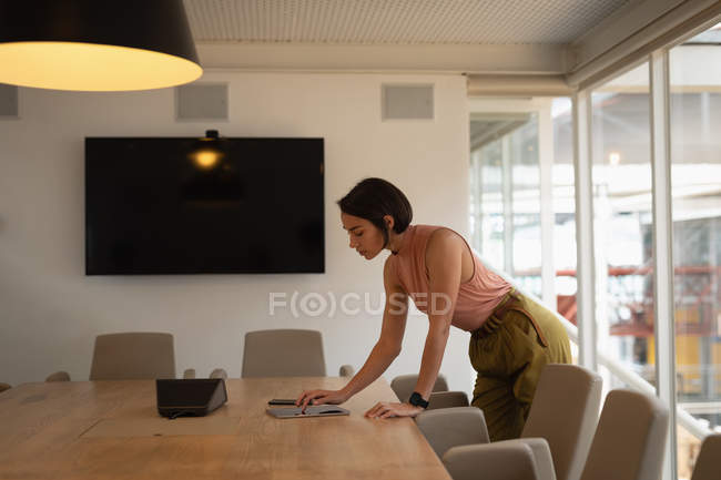 Side view of an Asian businesswoman using a digital tablet in the office — Stock Photo