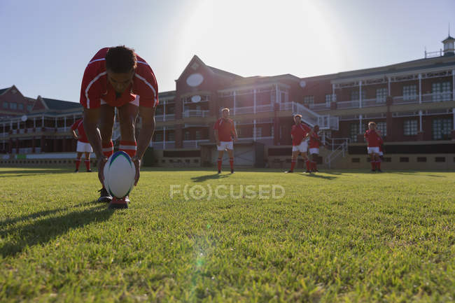 Front view of a young male African american rugby player placing the rugby ball on a kicking tee in the stadium — Stock Photo
