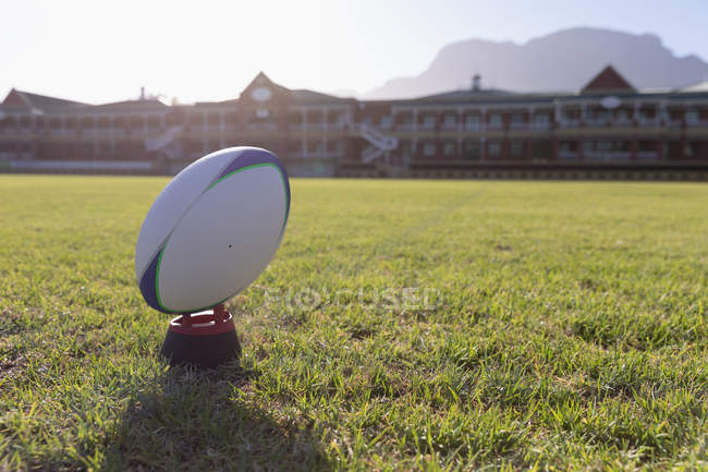 Primer plano de una pelota de rugby en una camiseta de patadas en el campo de rugby - foto de stock