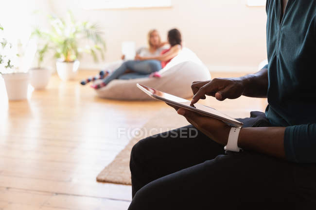 Средняя часть афро-американского мужчины использует цифровой планшет дома — стоковое фото