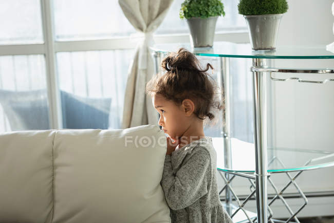Vista lateral da menina de pé em casa em pose triste — Fotografia de Stock