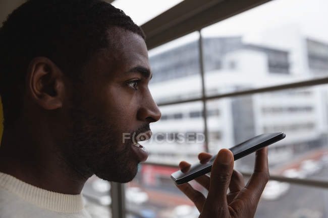 Primo piano dell'uomo d'affari afroamericano che parla al cellulare in ufficio — Foto stock