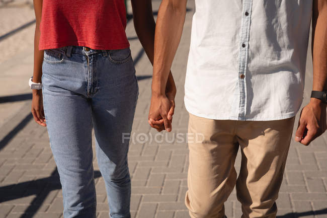 Mid section of couple standing, walking together near sea side — Stock Photo