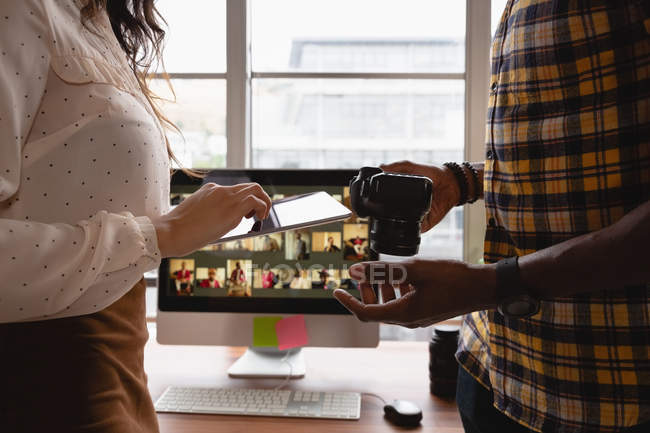 Mittelstand der Unternehmer diskutiert über digitales Tablet und Kamera im Büro — Stockfoto