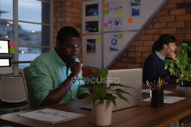 Front view of diverse business people working in office on night — Stock Photo