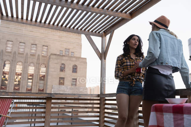 Niedrigwinkel-Ansicht multiethnischer Freundinnen, die zu Hause auf dem Balkon miteinander reden — Stockfoto