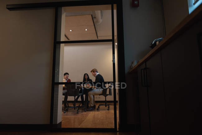 Vista de bajo ángulo de diversas personas de negocios discutiendo entre sí en la sala de conferencias en la oficina - foto de stock