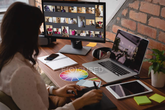 Seitenansicht einer Geschäftsfrau, die im Büro über ein Grafik-Tablet arbeitet — Stockfoto