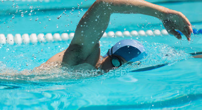 Primer plano de los jóvenes nadadores caucásicos nadando estilo libre en la piscina al aire libre en un día soleado - foto de stock