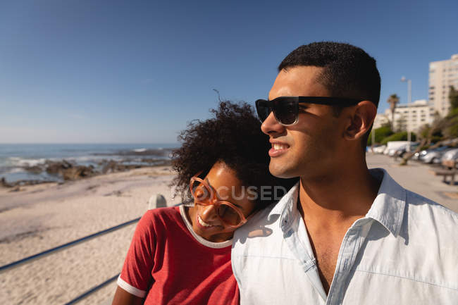 Вид спереди на афроамериканскую пару, прогуливающуюся и наслаждающуюся у моря, глядя на хобби — стоковое фото