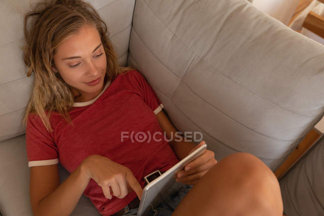 High angle view of woman using digital tablet in living room in sofa at home — Stock Photo