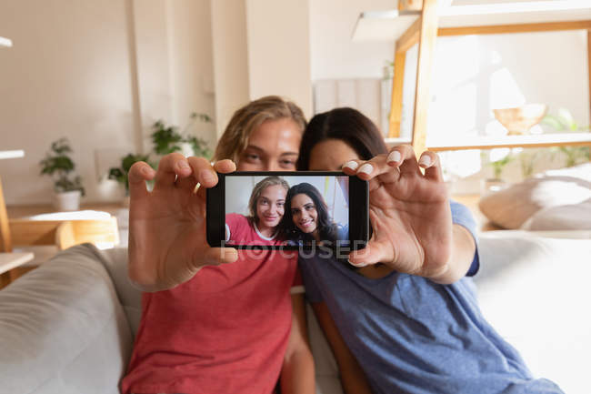 Frontansicht von Frauen, die zu Hause im Wohnzimmer ein Selfie machen — Stockfoto