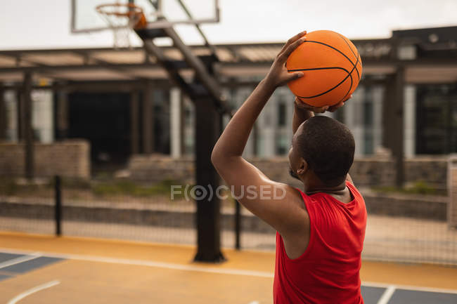 Visão traseira do jogador de basquete afro-americano jogando basquete na quadra de basquete — Fotografia de Stock