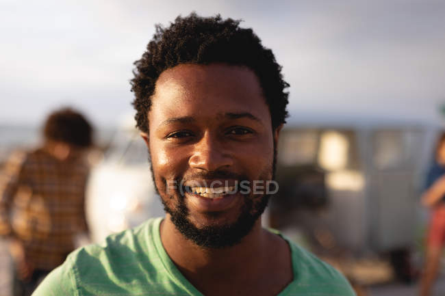 Porträt eines Afrikaners, der an einem sonnigen Tag am Strand steht und in die Kamera blickt — Stockfoto