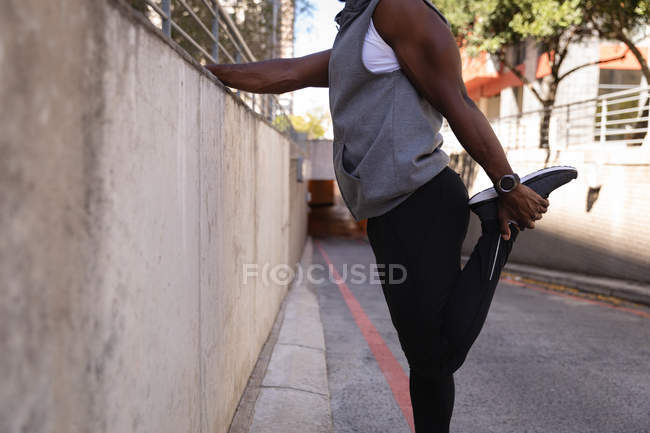 Seção média do homem fazendo exercício de alongamento na rua — Fotografia de Stock