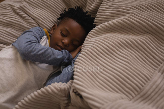 High angle view of little African-American boy sleeping on bed at home — Stock Photo