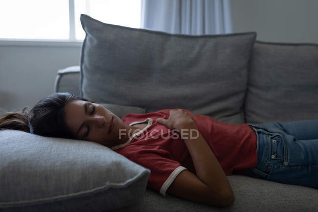 Seitenansicht der schönen Mischlingsfrau, die zu Hause auf dem Sofa schläft — Stockfoto
