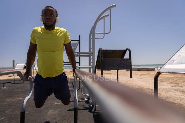 Frontansicht eines jungen afrikanisch-amerikanischen fitten Mannes, der an einem sonnigen Tag im Park Sport treibt — Stockfoto
