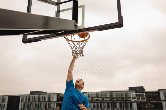 Vorderseite des kaukasischen Basketballspielers beim Basketballspielen auf dem Basketballplatz — Stockfoto