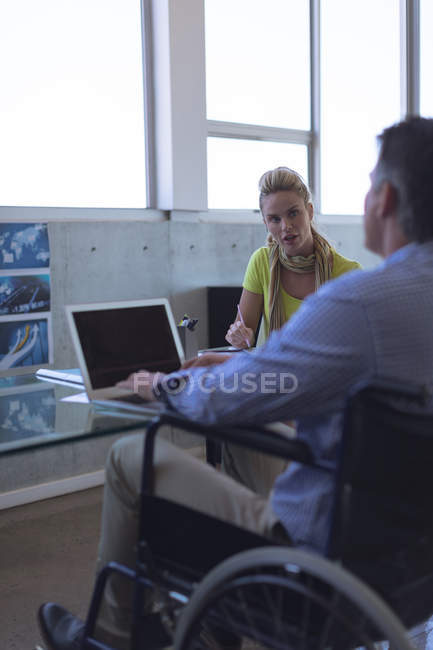 Disabled male and female executive interacting with each other in the office — Stock Photo