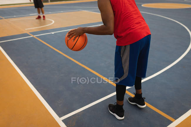 Visão traseira do jogador jogando basquete na quadra de basquete — Fotografia de Stock