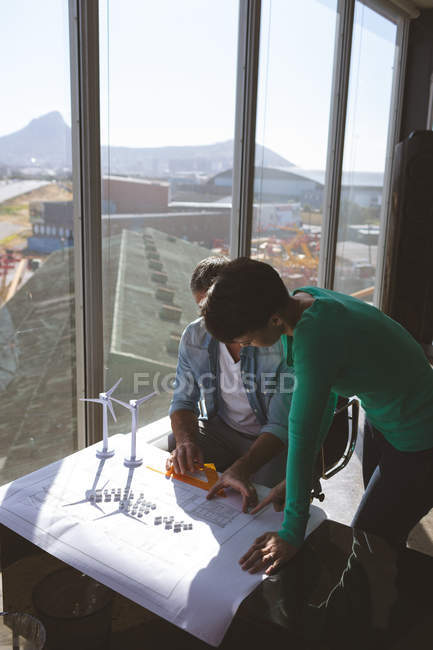 High angle view of Multi-ethnic architectures discussing over blue print at desk in modern office — Stock Photo