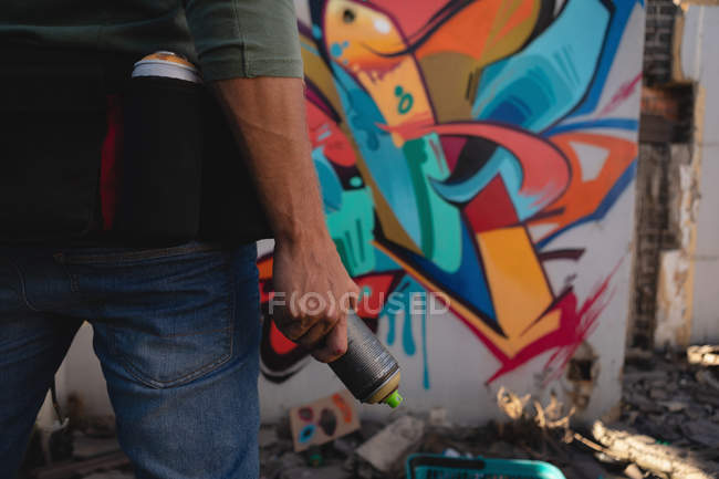 Vue arrière du jeune artiste graffeur caucasien debout avec peinture par pulvérisation à l'allée — Photo de stock