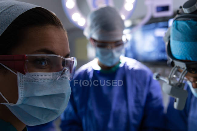 Primer plano de los cirujanos concentrados en quirófano durante la cirugía en el hospital - foto de stock